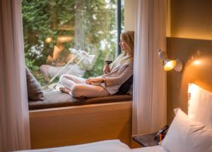 a woman sitting on a window sill with a glass of wine at The Guesthouse Vienna in Vienna