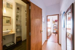 a bathroom with a sink and a mirror and a door at Sons do Mar - Charming Apartment by the Sea in Armação de Pêra +37 photos