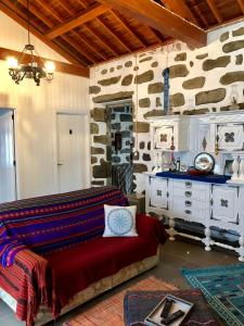 a living room with a couch and a stone wall at Casa Auri in Faial da Terra