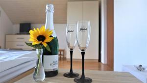 a bottle of champagne and two wine glasses on a table at Vineyard Cottage Zajc in Semič