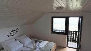 ein Schlafzimmer mit einem Bett und einem großen Fenster in der Unterkunft Vineyard Cottage Zajc in Semič