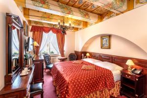 ein Hotelzimmer mit einem Bett mit einer roten Tagesdecke in der Unterkunft Hotel U Zlatého Stromu Prague by BHG in Prag