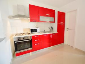eine Küche mit roten Schränken und einer Mikrowelle in der Unterkunft Apartment Leko-3 by Interhome in Novi Vinodolski + 30 Fotos