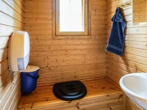 ein Holzbadezimmer mit einem WC und einem Waschbecken in der Unterkunft Holiday Home Naurulokki 4 by Interhome in Strandby + 7 Fotos