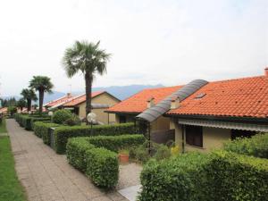 eine Reihe von Hecken vor einem Haus mit Bäumen in der Unterkunft Apartment La Romantica by Interhome in Brezzo