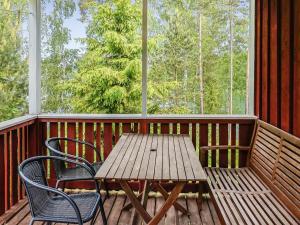 ein Holztisch und zwei Stühle auf einer Veranda in der Unterkunft Holiday Home Naurulokki 4 by Interhome in Strandby