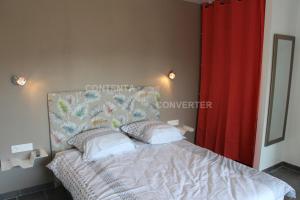 a bedroom with a bed and a red curtain at appartement coubillou in Lamalou-les-Bains +2 photos