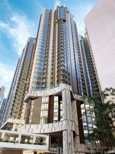 a tall building with many windows in a city at Hotel Alexandra in Hong Kong