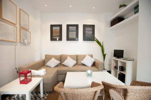 uma sala de estar com um sofá e uma mesa em Apartamentos Calle Rosario em Sevilha