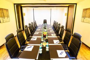 a long boardroom with a long table and chairs at Flora Airport Hotel and Convention Centre Kochi in Nedumbassery