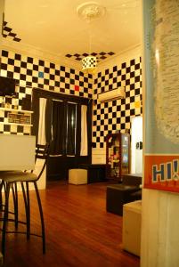 a living room with checkered walls and a table and chair at Hostel La Casona de Don Jaime 2 and Suites HI in Rosario