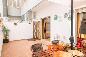 a patio with a wooden table and chairs at Sons do Mar - Charming Apartment by the Sea in Armação de Pêra