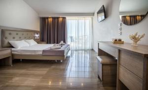 a bedroom with a bed and a large window at Green Bay in Limenaria