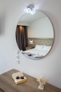 a mirror in a room with a bed and a table at Green Bay in Limenaria