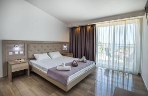 a bedroom with a bed and a large window at Green Bay in Limenaria