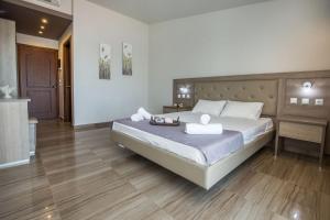 a bedroom with a large bed with two towels on it at Green Bay in Limenaria