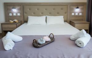 a bed with towels and pumpkins in a basket on it at Green Bay in Limenaria