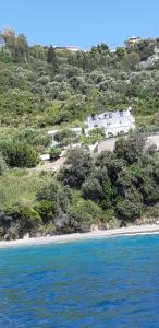 a white house on a hill next to the ocean at ΑRILLA STUDIOS in Perdika
