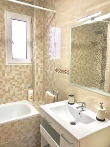 een badkamer met een wastafel, een bad en een spiegel bij Cozy apartment in Valencia! WI-FI ! in Valencia