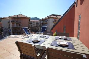 einen Holztisch und Stühle auf dem Balkon in der Unterkunft La casa al mare in Sestri Levante