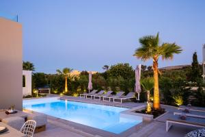 una piscina con tumbonas y una palmera en Vasilios Villa, Luxury Escape, By ThinkVilla, en Loutra