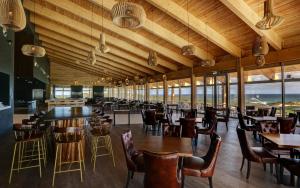 a restaurant with wooden ceilings and tables and chairs at West Cliffs Ocean and Golf Resort in Casal da Lagoa Seca