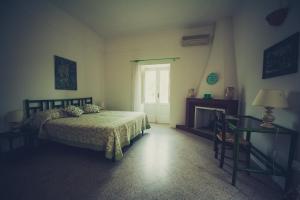 Schlafzimmer mit einem Bett, einem Kamin und einem Fenster in der Unterkunft Masseria Perronello Country House in Castellaneta Marina 