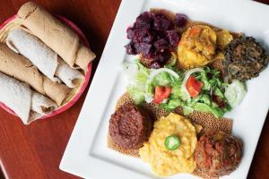 un plato de comida con una ensalada y un sándwich en Merkeza Guest House, en Lalibela