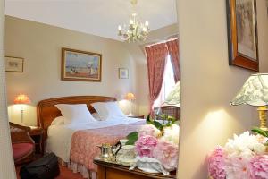 a bedroom with a bed and flowers on a table at Hostellerie de la Motte jean in Saint-Coulomb