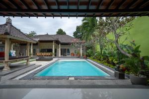 a swimming pool in the backyard of a house at The Catur Villa Seminyak in Seminyak