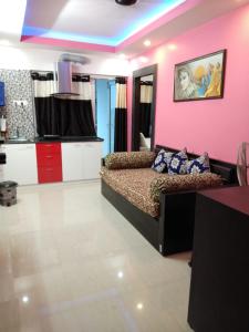 een slaapkamer met een bed en een roze muur bij Shonar Kutir in Puri