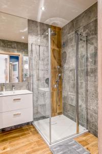 La salle de bains est pourvue d'une douche et d'un lavabo. dans l'établissement Apartament Merkury z parkingiem, à Toruń