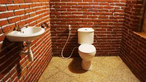 a bathroom with a toilet and a sink in a brick wall at Vanilla Garden in Tetebatu +52 photos
