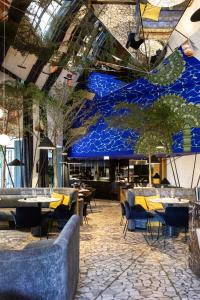 a restaurant with tables and chairs and a blue wall at Hotel Square in Paris