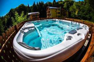 a large hot tub on the side of a house at Hotel Trei Brazi in Băile Olăneşti