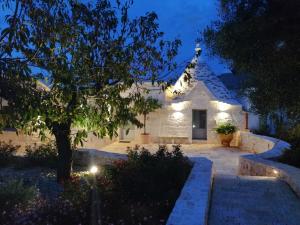 a white building with lights in front of it at night at Trullo Genesi in Cisternino