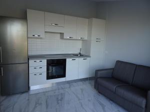 una cocina con armarios blancos y un sofá negro en Appartamento Indipendente in Villa - Golf Del Sur en San Miguel de Abona