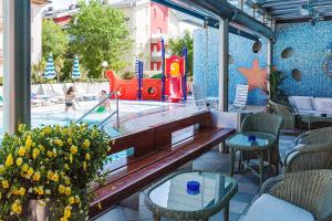 eine Außenterrasse mit Spielplatz und Rutsche in der Unterkunft Hotel Mayer in Bibione
