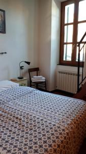 a bedroom with a bed and a chair and a window at La Ginestra in Corniglia