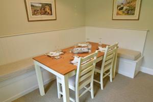 a dining room with a table and some chairs at Gardeners Cottage in Chesthill