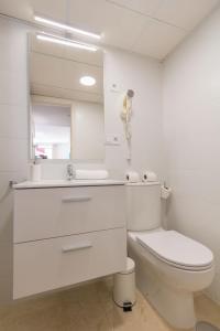 een witte badkamer met een toilet en een spiegel bij Bamberg Central Suite by Valcambre in Sevilla