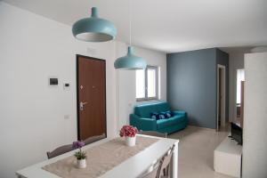 a kitchen and living room with a blue couch at CASA VITTORIA in Gravina in Puglia