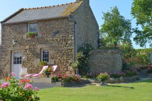 a stone house with a chair in front of it at Hostellerie de la Motte jean in Saint-Coulomb