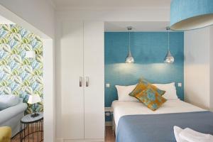 a bedroom with a bed and a blue wall at Rainha II Beach Apartment in Cascais