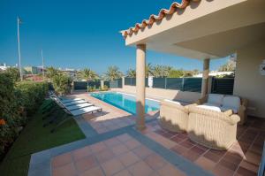 a patio with chairs and a swimming pool at Villa Meloneras in Meloneras