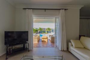 a living room with a couch and a television at Villa Meloneras in Meloneras