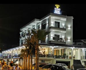 a large white building with a sign on it at King Hotel Ksamil in Ksamil