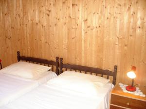 two beds in a room with wood paneled walls at Apartment Lucija in Korčula