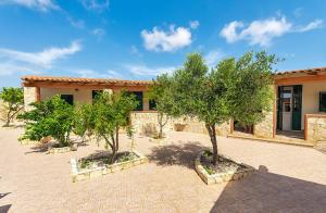 two trees in a courtyard in front of a building at Appartamenti Pomelia - Lampedusa in Lampedusa