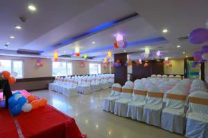 een feestzaal met witte stoelen en ballonnen bij Hotel Abhimaani Vasathi, Rajajinagar in Bangalore